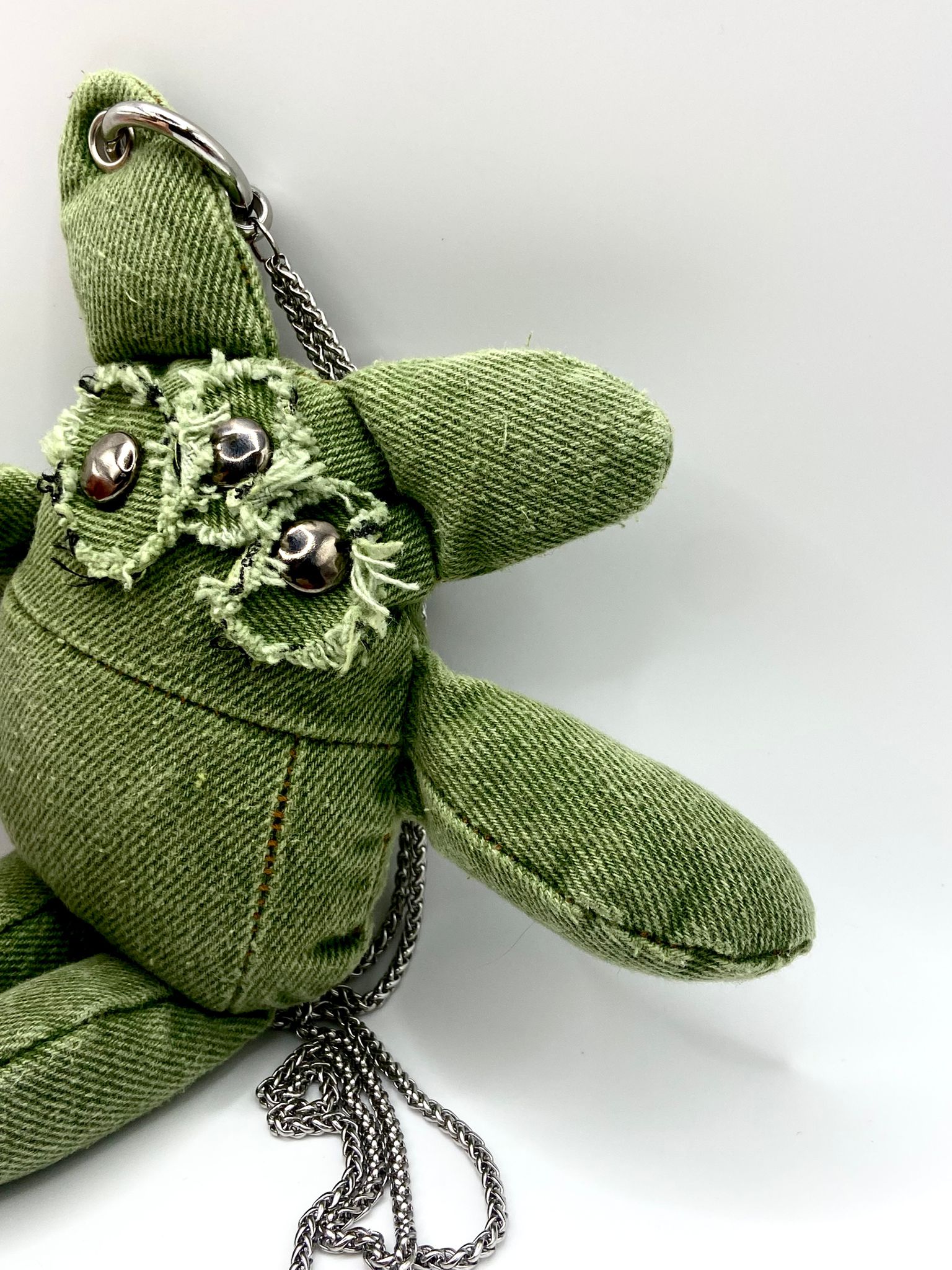 Side profile monster plush phone holder — artisanal denim creation — handcrafted personalized accessory. 